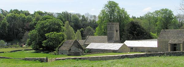 View across fields to farmyard buildings and the church