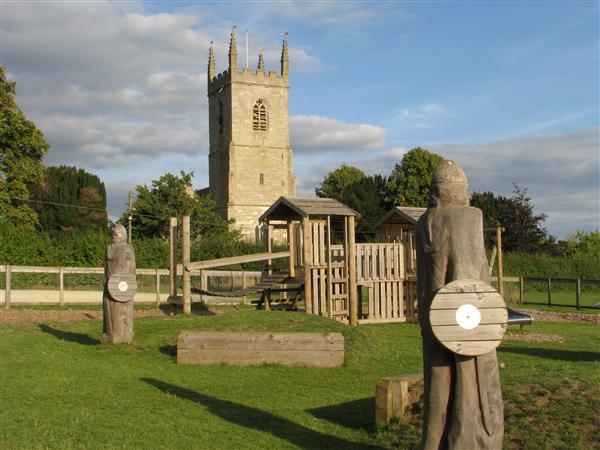 Playground equipment, with a church tower inthe background